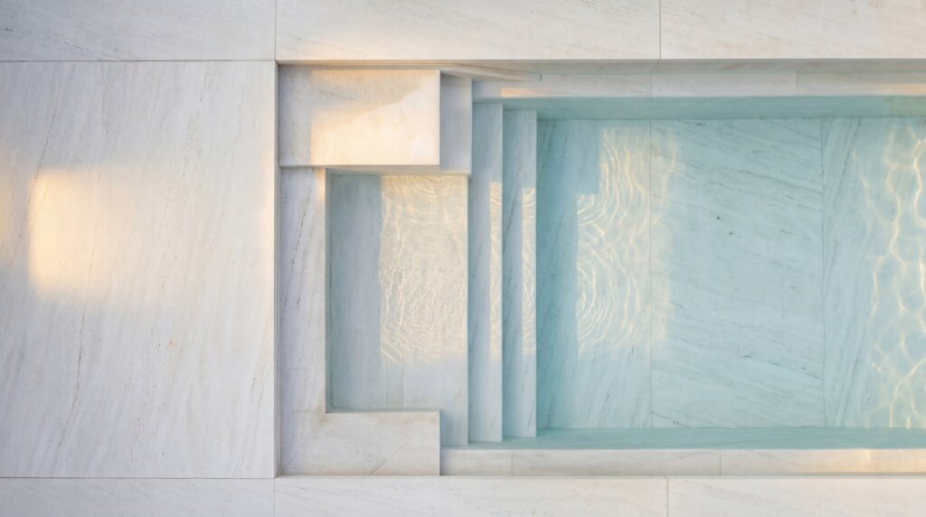 Close detail of nano-crystallized glass steps descending into the pool.